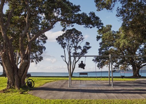A woman swings alone at the beach