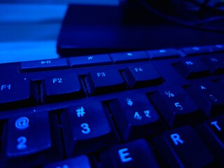 Close-up of a modern computer keyboard with sleek keys, ideal for illustrating digital workspaces,...