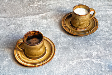 Cup of black coffee and cup of milk