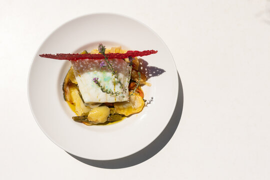 a dish of hake with vegetables and pretty decoration