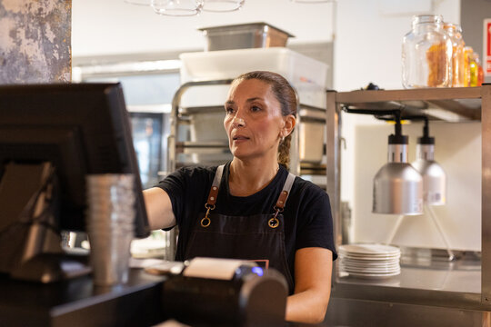 a woman doing a customer's check in a restaurant