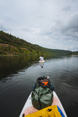 Embark on an exhilarating paddleboarding journey through serene waters, surrounded by vibrant greenery and captivating skies. Perfect for nature lovers and adventurous thrillseekers alike