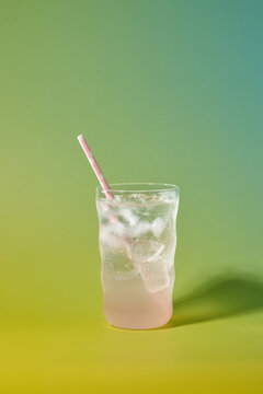 A tall, refreshing drink filled with ice and a pink straw