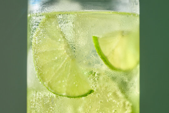 A close-up shot of a refreshing cocktail with lime slices submerged