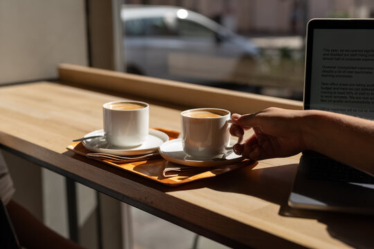 Enjoying Coffee at a Cafe With Laptop on a Sunny Day