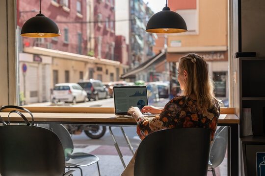 Woman working on the table near window in coffee shop