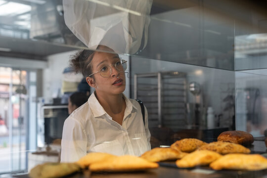 Woman buying snacks at bakery while commuting to work
