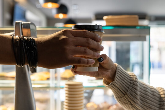 Barista giving fresh coffee to client