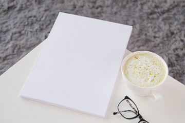 blank magazine mockup on coffee table with green matcha tea near window