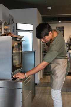 Baker adjusting oven control knob