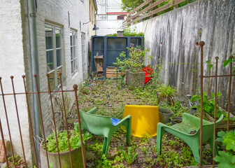 Untidy Backyard with Overgrown Grass and Old Furniture