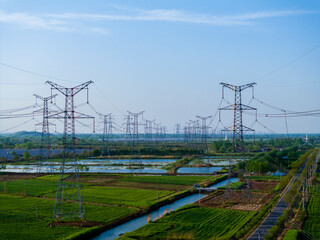Aerial View of High Voltage Transmission Towers Standing in Fields