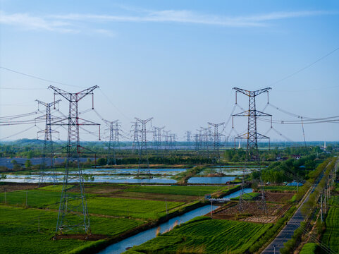 Aerial View of High Voltage Transmission Towers Standing in Fields