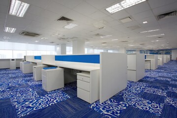 Modern office space with rows of white desks and blue partitions