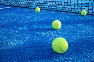 Sports background: a group of padel balls on a textured blue court.