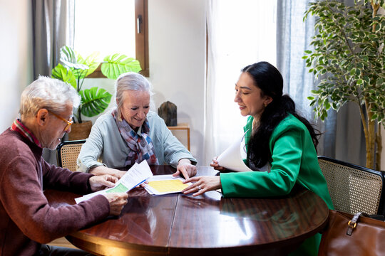 Financial advisor explaining options to senior couple at home