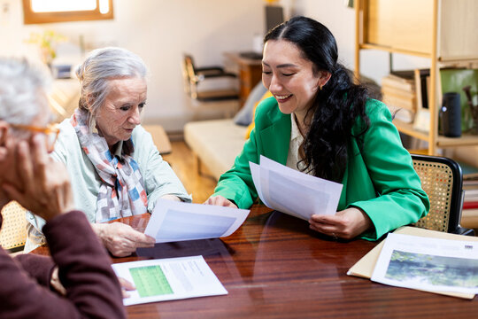 Financial advisor explaining options to senior couple at home