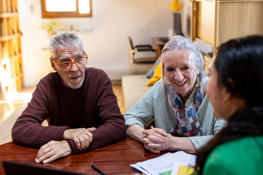Happy senior couple meeting with financial advisor at home 