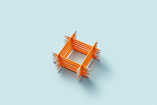 Stacked square structure made of orange pencils