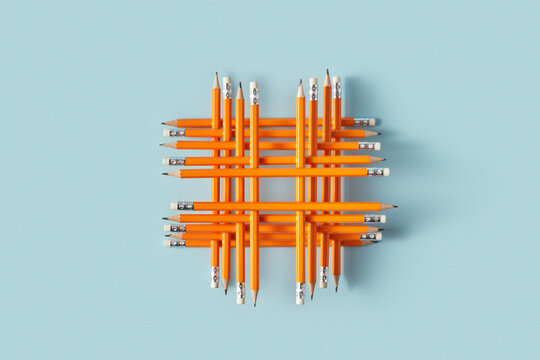 Geometric grid of orange pencils on blue background