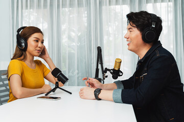 Smiling radio influencer host wearing headphone interviewing woman speaker sharing information to...