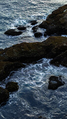 Dark blue ocean waves crashing on rocks