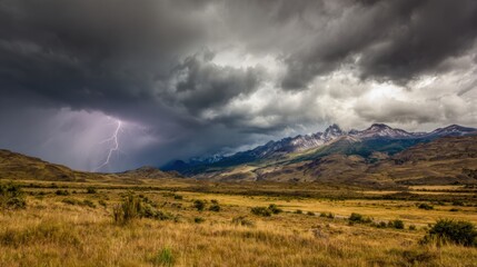 Dark storm clouds roll over a sprawling mountain range, with flashes of lightning illuminating the sky. The grassy terrain contrasts with the brewing tempest, showcasing nature's power.