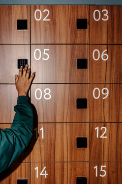 Hand Entering Code on Wooden Locker Keypad