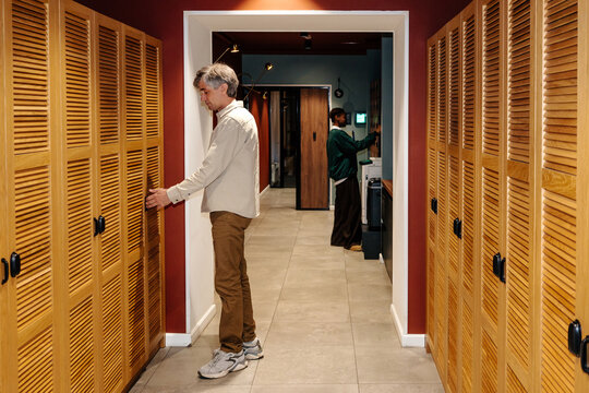 People Using Storage Lockers and Office Printer in Shared Workspace