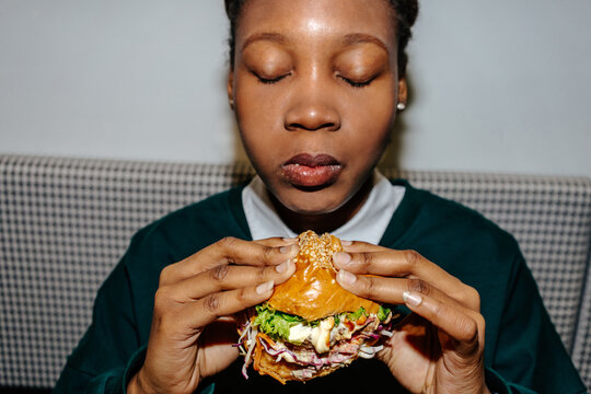 Close-up of woman enjoying juicy burger