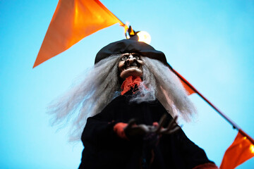 Wrinkled old pirate with white hair and black hat isolated on sky blue background.