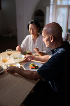 Couple shares a quiet meal in soft light.