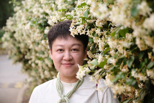 Chinese woman under the jasmine wall with wind chimes