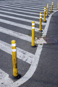Many yellow bollards and stripes on the street