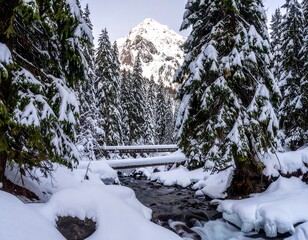 Snowy mountain valley with a wooden bridge