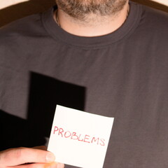 The concept of a problem. A person holds a piece of white paper with the word problem written on it