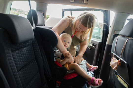 Mother put her baby in a safety car seat 
