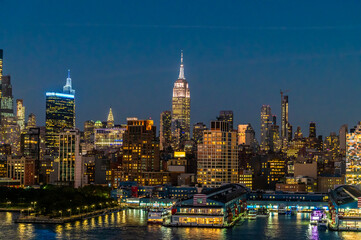 Naklejka premium A view at night sailing down the Hudson River towards the illuminated cityscape off Manhattan, New York, in the fall