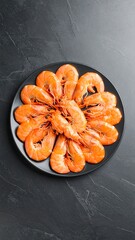 Raw shrimp arranged on dark plate