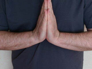 The concept of Zen. Calmness and balance within. A middle aged man's hands are folded in a boat...