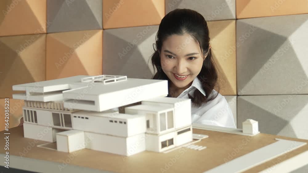 Poster skilled attractive architect engineer holds architect model while checking mistake point carefully. 