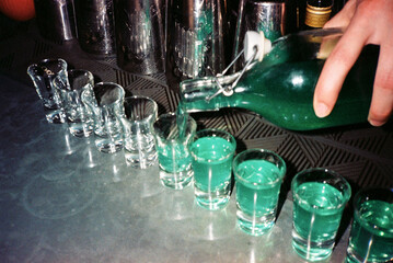 Shot Drinks Being Prepared in a Bar at Night