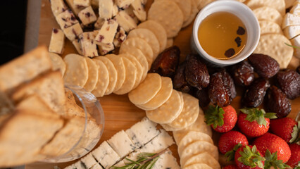 Elegant gourmet cheese board with fresh fruits, dried fruits, honey, nuts and artisanal snacks. Perfect for wine nights, brunch or luxury entertaining