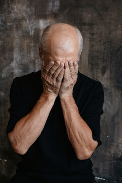 Mature man hiding face with hands