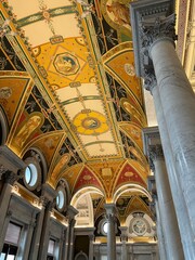 Intricately painted vaulted ceiling and marble columns at the Library of Congress in Washington D.C., showcasing neoclassical design, vibrant murals, and stunning historic architecture