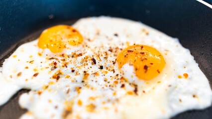 Golden fried eggs with fresh farm herbs, perfectly seasoned and rustic. Appetizing breakfast photography for chefs, food blogs, and organic farm marketing