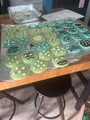 Homemade blue and green sugar cookies with fun polka dot and doodle designs, decorated with icing for a cute and whimsical homemade baking project on a wooden kitchen counter