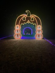 Glowing Halloween pumpkin archway with stacked jack-o’-lantern lights creating a magical illuminated tunnel perfect for spooky night walks, haunted attractions, and festive Halloween light displays