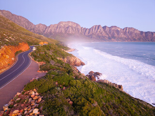 Aerial of long coastal road at sunset