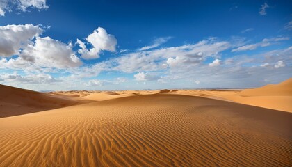 breathtaking landscape of vast sandy dunes under bright blue sky with fluffy white clouds in a tranquil and idyllic natural setting